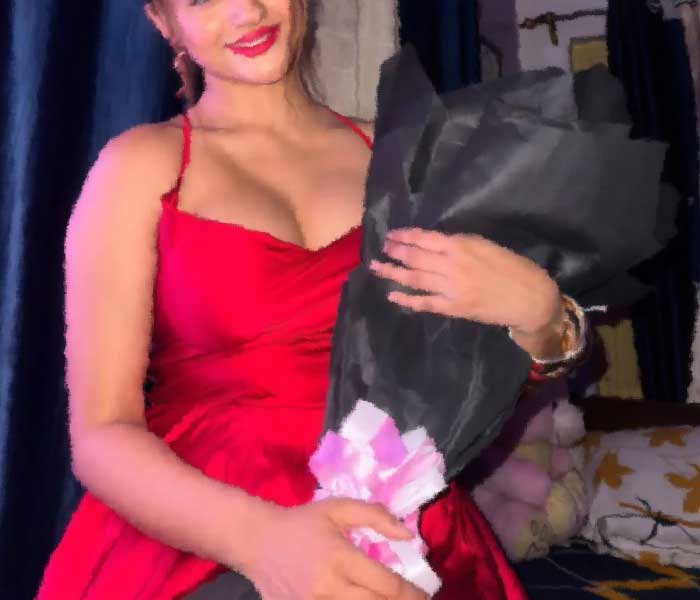 very pretty Bangalore Escort girl in red dress, holding flower bouquet